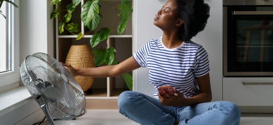 Young,Black,Woman,Sits,On,Floor,With,Smartphone,,Tries,To